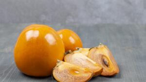 Sliced delicious persimmon in a wooden table Uchuva Liofilizada 15g